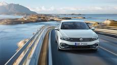 White Volkswagen Passat Hybrid driving over a bridge White Volkswagen Passat Hybrid driving over a bridge