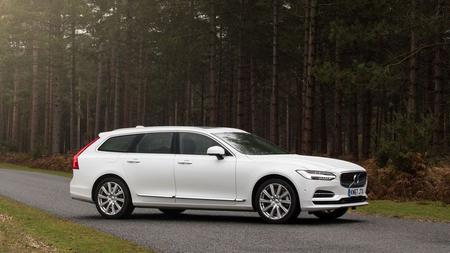 Volvo V90 White Volvo V90 driving through a wood