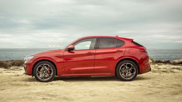 Red Alfa Romeo Stelvio parked on a coastal headland