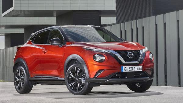 Red Nissan Juke parked near modern buildingd