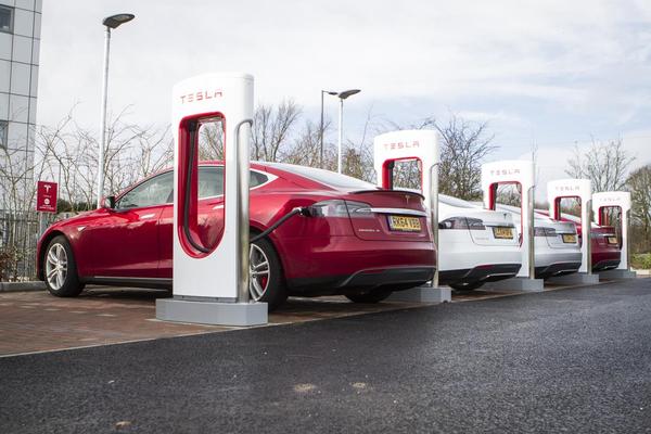 Red Tesla electric car in a bespoke charging station