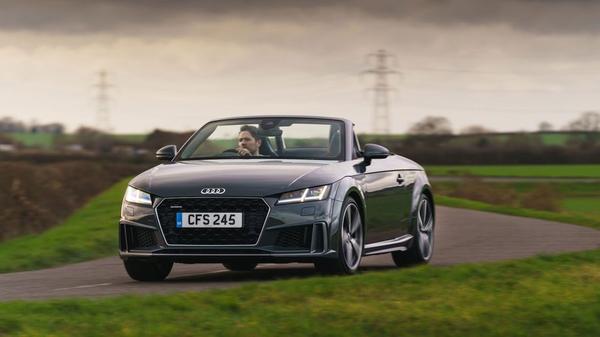 Black Audi TT convertible driving through the countryside