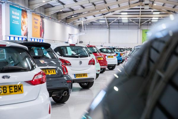 A car showroom with multiple cars parked inside