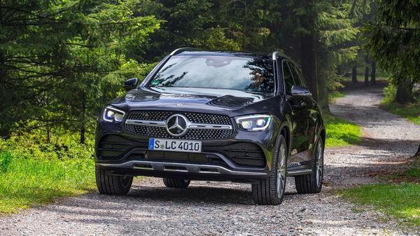 Black Mercedes-Benz GLC driving through a woodland