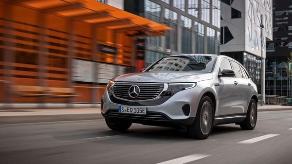 Silver Mercedes Benz EQC driving through a city