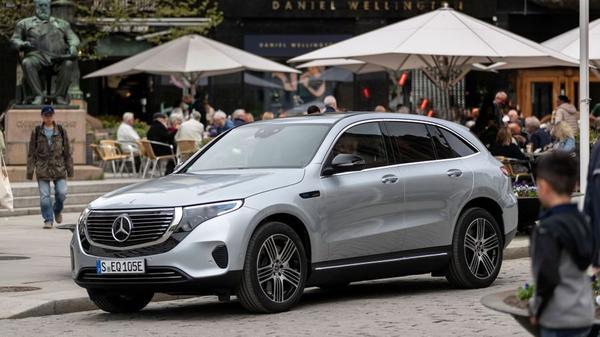 Silver Mercedes Benz EQC electric car parked in a crowd of people
