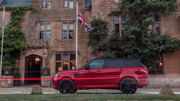 Red Range Rover Sport Hybrid parked outside a stately home