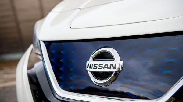 Close up of a white Nissan Leaf's badge