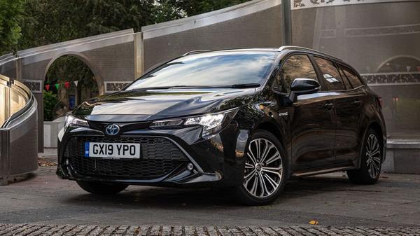 Black Toyota Corolla parked on a walled driveway
