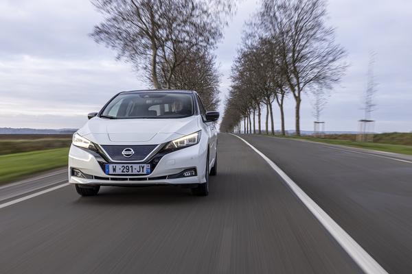 White Nissan Leaf driving on a quiet road