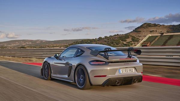 Brown Porsche 718 Cayman rear driving on a track