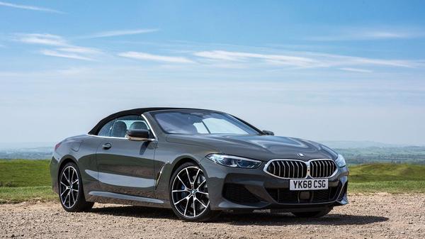 BMW 8 Series convertible parked in front of a blue sky