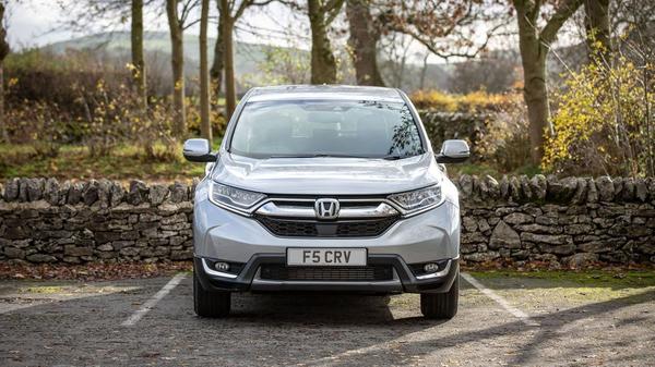 Honda CR-V Hybrid parked near a woodland