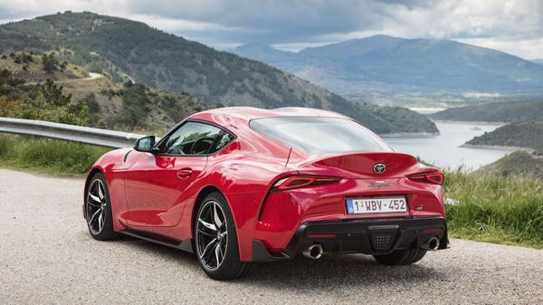 Red Toyota Supra coupe parked in a mountain range