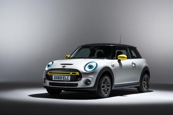 White and yellow Mini Electric parked in a showroom