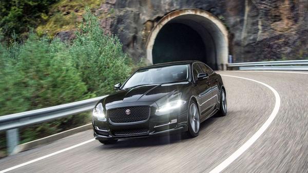 Black Jaguar XJ drives out of dark tunnel