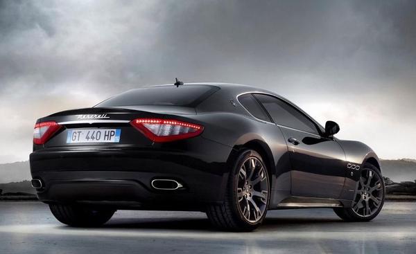 Rear of black Maserati GranTurismo against stormy sky