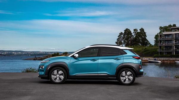 Blue Hyundai Kona parked against a blue sky