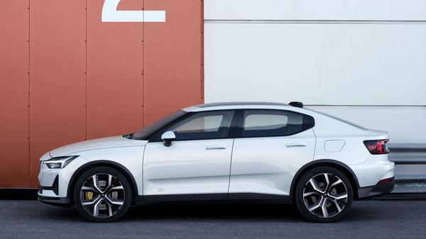 White Polestar 2 (2020 edition) parked against a storage unit