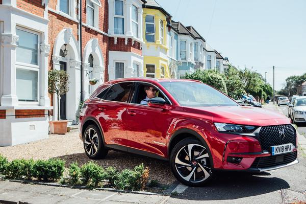 A driver sits in a red DS car, about to take a home test drive