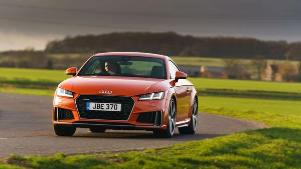 Orange Audi TT coupe driving through fields