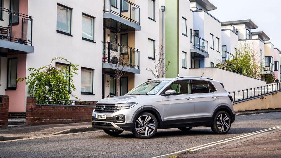 Volkswagen T-Cross White Volkswagen T-Cross parked in front of colourful apartments