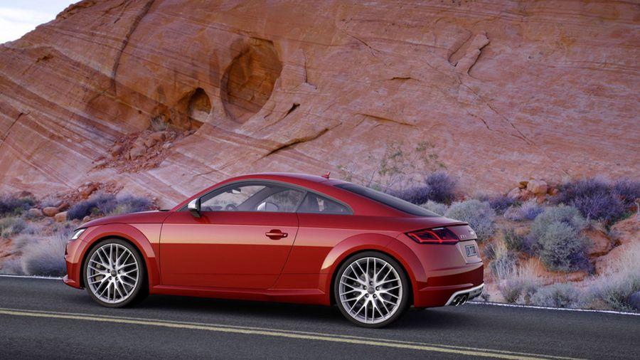 New car driving by a cliffside