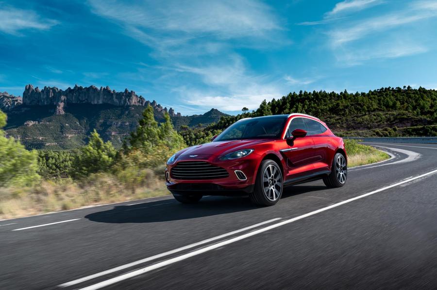Aston Martin DBX Red Aston Martin DBX driving beneath a blue sky