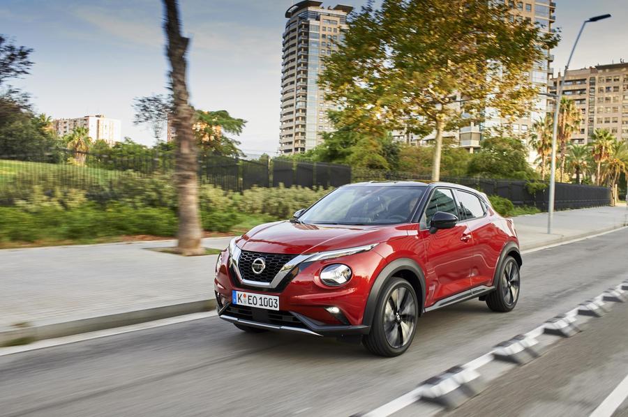 Nissan Juke Red Nissan Juke driving through suburban streets