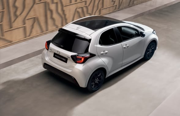 A white Mazda2 on the road