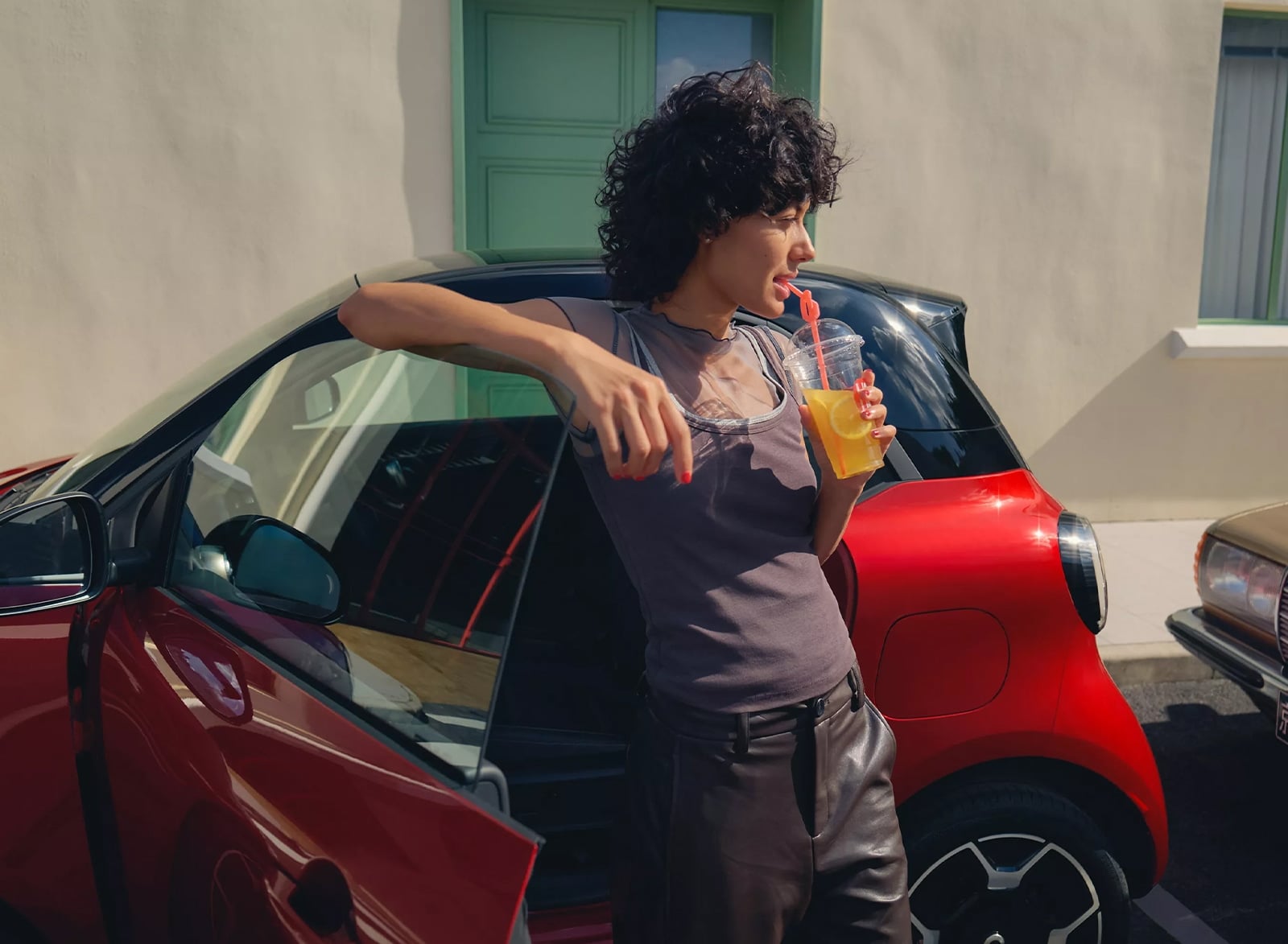 Woman standing in front of a red smart #2 with the door open