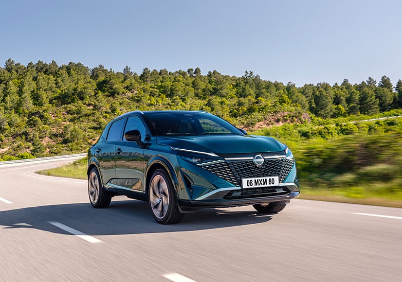 Green Nissan Qashqai front view on road