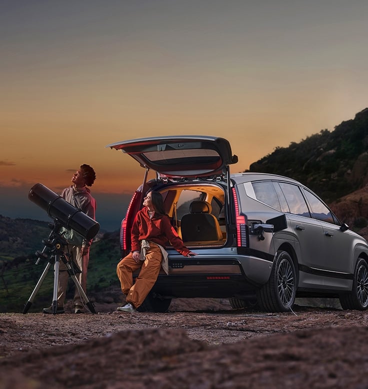 Big cargo space, top versatility couple at sunset with large telescope by car.