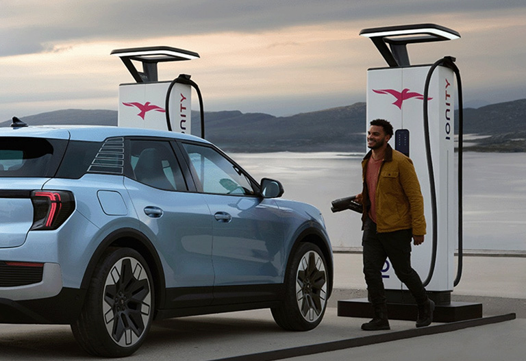 Man using an IONITY charging point to charge his Ford Explorer