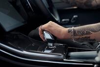 A person's hand on the gear stick of a Range Rover Sport