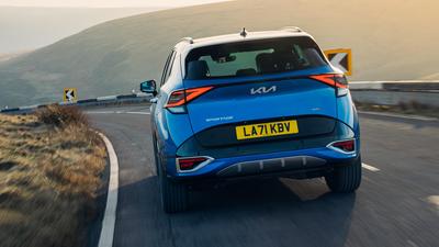 2022 Kia Sportage in blue rear view driving along country road