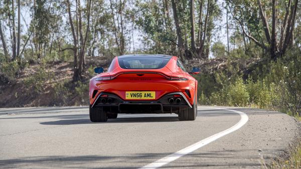 2024 Cosmos Orange Aston Martin Vantage rear driving on road